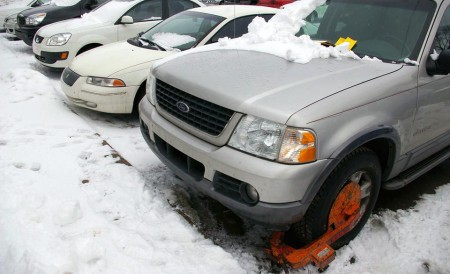 Getting the Boot: A vehicle sits trapped in the parking lot near the Music Building after recieving a number of tickets, a boot, and a notice reading: “WARNING: DO NOT MOVE THIS VEHICLE.” Students’ concerns about the parking situation on campus are heightened during these winter months when the lines defining parking spots are covered in snow. Photo By: Kristyn Sonnenberg | Photo Editor
