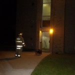 A fire fighter monitors a fan being used to remove smoke from North Bond Hall after a grease fire. Photo by Kelsey A. Schnell | Ferris State Torch
