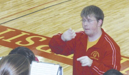 Jason Workman: Jason Workman, Ferris State senior in biotechnology and student conductor of the FSU Athletic Pep Band, leads the group during a basketball game. Workman has done the same for 3,500 songs at 140 events. Photo Courtesy of Dale Skornia,
