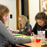 Spreading Holiday Cheer: Hannah Rillema, Jessica Swanson, and Emma Holmi, above from left to right, make holiday cards for soldiers overseas. Photo By: Brock Copus | Photographer