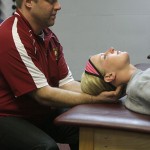 Behind the Scenes: Trainer Tim Glover helps stretch out Makenzi Peterson, a junior on the softball team. Trainers are the people behind the scenes that help Bulldog athletes stay healthy. Photo By: Michael Fleming | Web Editor